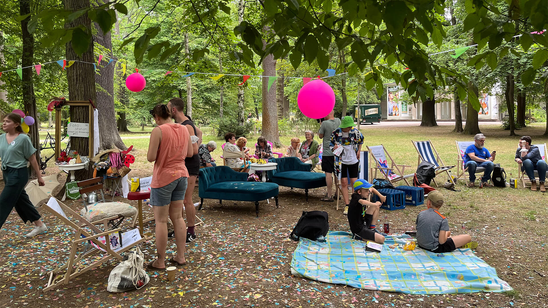 Menschen sitzen bei der Eröffnung draußen zusammen 