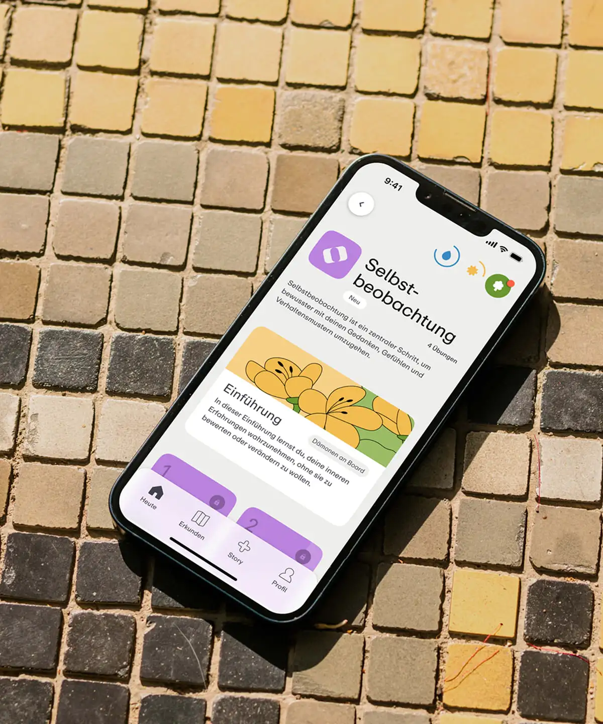 Smartphone auf einer gefliesten Oberfläche, mit der geöffneten Mindgarden App.